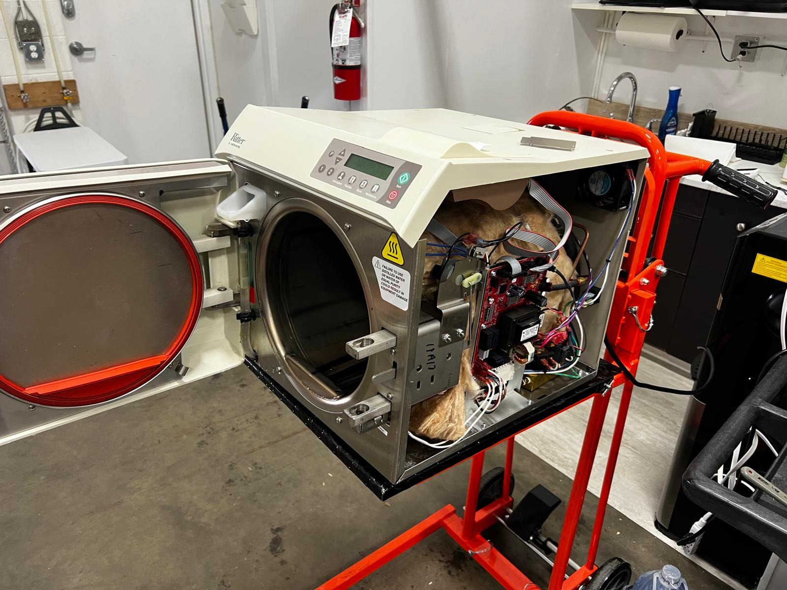 Autoclave with no power being inspected by a dental equipment technician